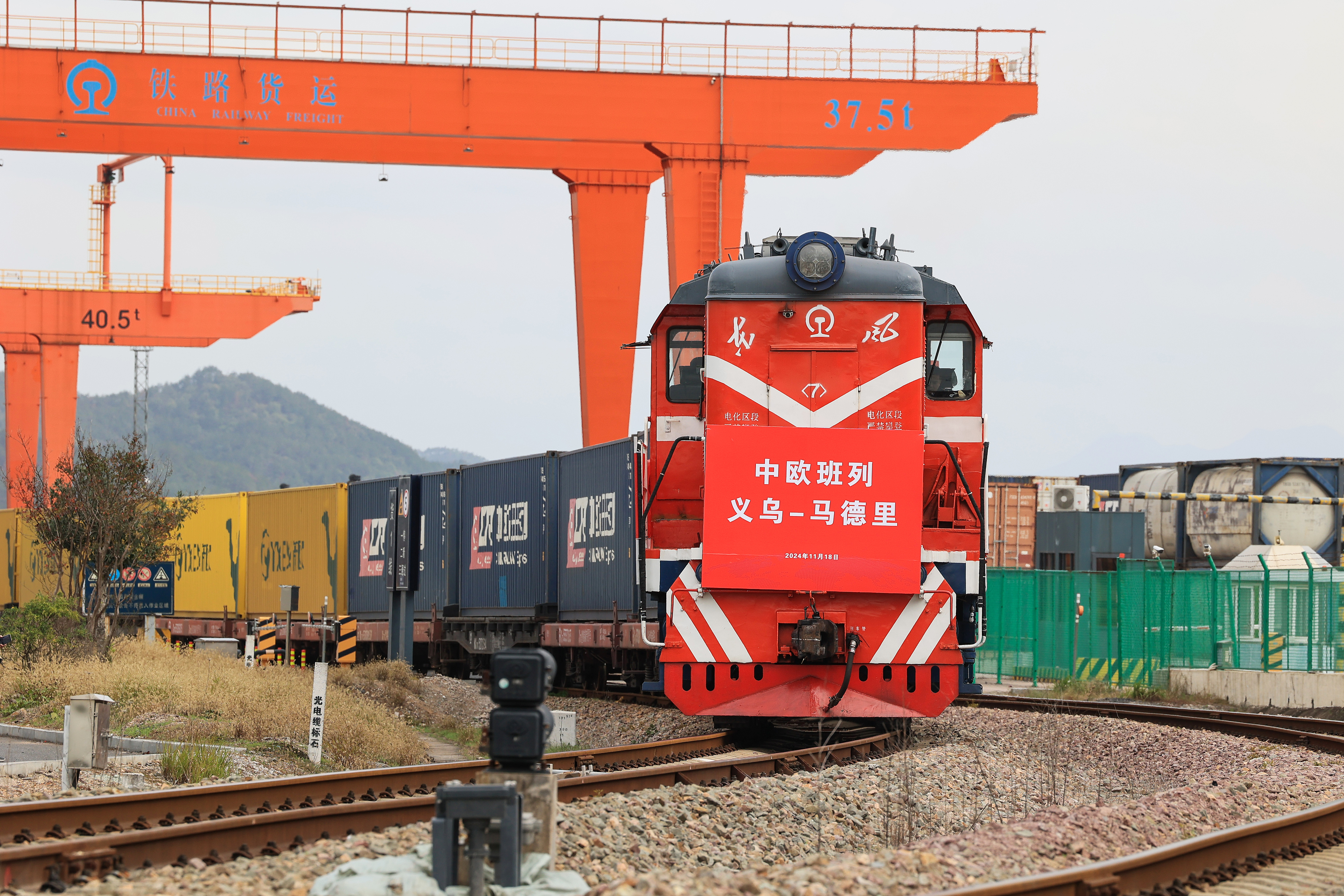 2024年11月18日，一趟滿載110個(gè)標(biāo)準(zhǔn)箱日用百貨、汽車配件、機(jī)械設(shè)備等出口貨物的中歐班列從鐵路義烏西站駛出，開往逾1.3萬(wàn)公里外的西班牙馬德里。