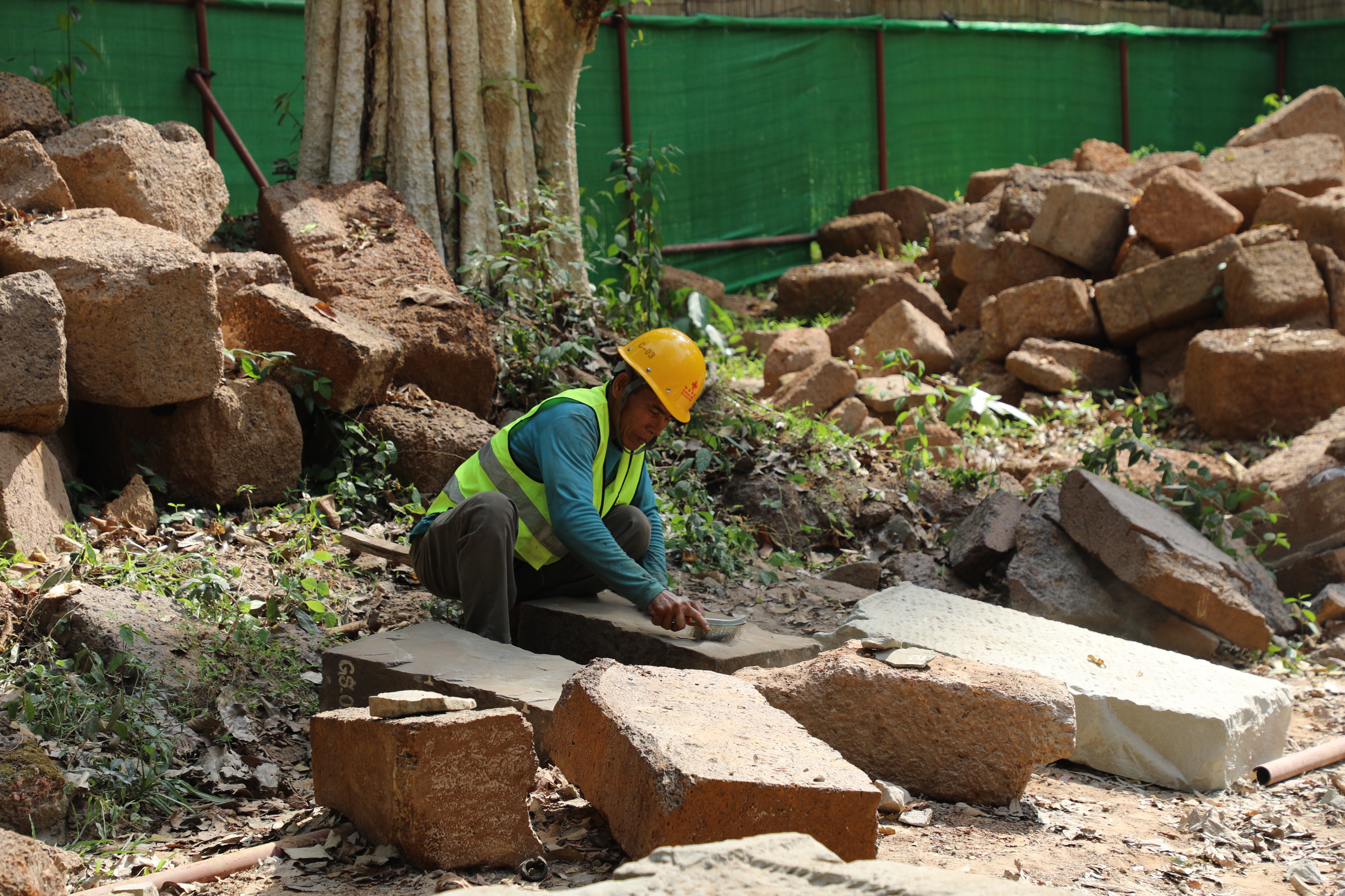 一名柬埔寨工人正在王宮遺址修復(fù)現(xiàn)場(chǎng)工作。（人民日?qǐng)?bào)記者曹師韻 攝）