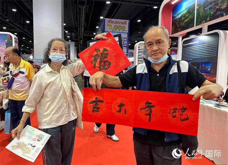 2025蛇年春節(jié)，泰國市民展示他們領(lǐng)到的華人手寫春聯(lián)。人民網(wǎng)記者 簡承淵攝