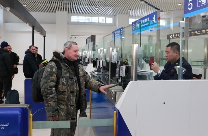 2024年12月10日，在黑河公路口岸旅檢大廳，黑河出入境邊防檢查站民警為首班次客車入境旅客辦理邊檢通關(guān)手續(xù)。當(dāng)日，中國黑河公路口岸—俄羅斯卡尼庫爾干公路口岸旅客運輸正式開通。新華社發(fā)（劉松攝）