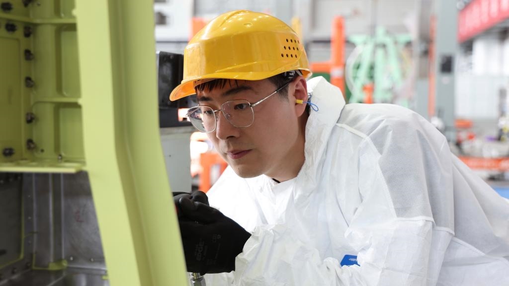 在中國(guó)航空工業(yè)集團(tuán)成飛車(chē)間內(nèi)，飛機(jī)鉚裝鉗工首席操作技師馮攀龍正在工作。（新華社發(fā)）