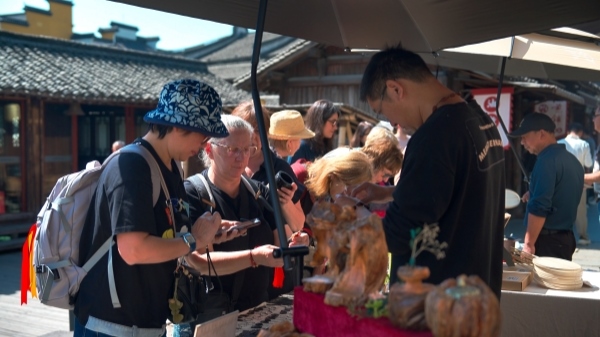 “五一”期間，游客正在烏鎮(zhèn)“水鄉(xiāng)碼頭”挑選購買文創(chuàng)產(chǎn)品。受訪者供圖