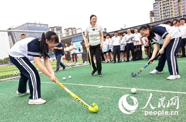 陳朝霞（中）指導(dǎo)學(xué)生體驗(yàn)曲棍球。 人民網(wǎng)記者 楊磊攝