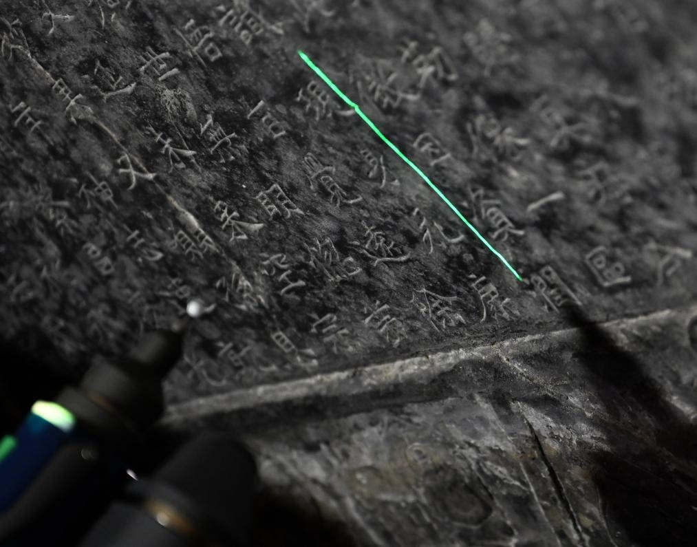 2025年4月9日，龍門(mén)石窟研究院工作人員在古陽(yáng)洞使用關(guān)節(jié)臂掃描儀對(duì)《龍門(mén)二十品》之一進(jìn)行數(shù)字化掃描。新華社記者 李嘉南 攝