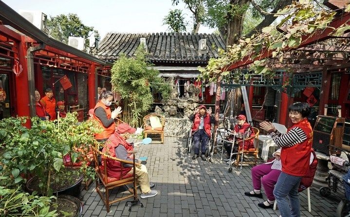 2024年10月12日，鐘樓灣胡同的老年人在社區(qū)內(nèi)的四合院養(yǎng)老驛站休閑。2017年起，北京市先后開(kāi)展了兩輪背街小巷環(huán)境整治提升行動(dòng)，完整保留了中軸線生活建筑群的歷史信息，并根據(jù)居民的生活和居住方式進(jìn)行適配化的更新和改造，極大地改善了生活環(huán)境。2023年鐘樓灣胡同被評(píng)為“北京最美街巷”。