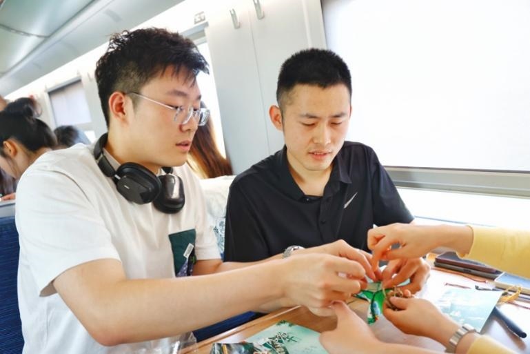 G232次旅客親手制作端午荷包和五彩繩。王磊攝