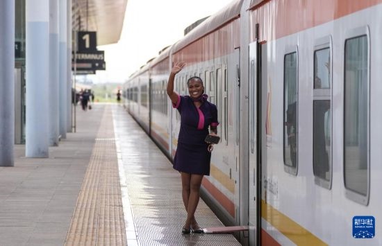 5月31日，在蒙內(nèi)鐵路內(nèi)羅畢站，一名乘務(wù)員在即將開往蒙巴薩的E2次列車旁等候乘客。新華社記者 李亞輝 攝
