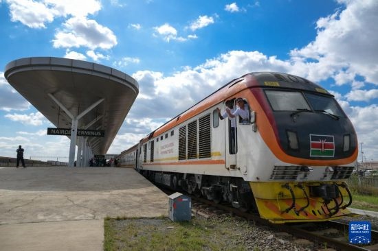 5月31日，在蒙內(nèi)鐵路內(nèi)羅畢站，機車駕駛員蔣立平（右）和博爾在即將開往蒙巴薩的E2次列車上揮手致意。新華社記者 楊光 攝