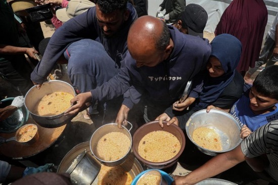 5月28日，人們?cè)诩由吵俏鞑康纳程犭y民營(yíng)領(lǐng)取救助食物。新華社發(fā)（里澤克·阿卜杜勒賈瓦德攝）