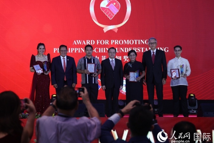 黃溪連大使和菲中了解協(xié)會主席與榮獲“友誼獎”的獲獎者合影留念。人民網記者 樊帆攝